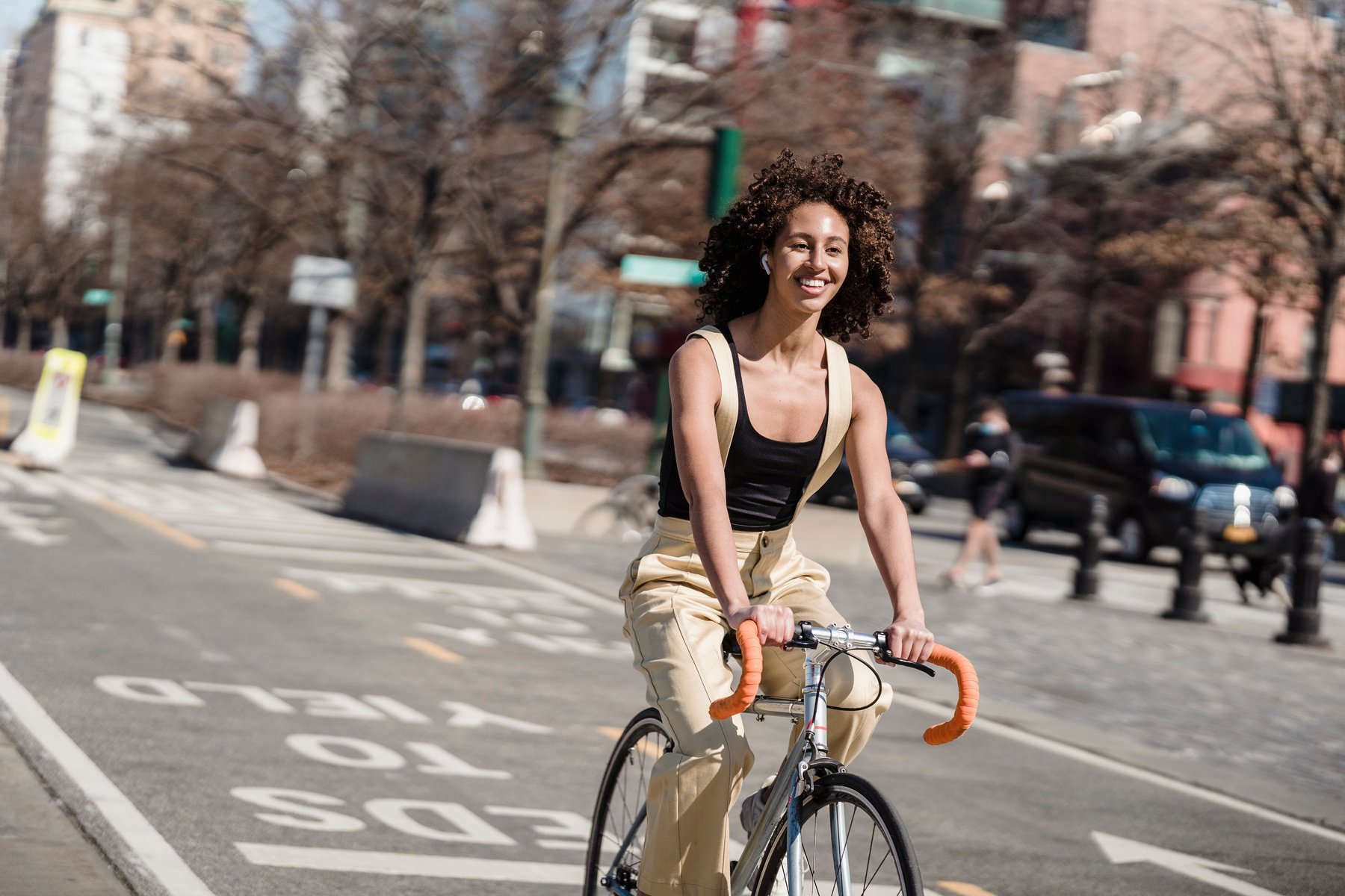 A Smiling Woman Riding a Bicycle in the City